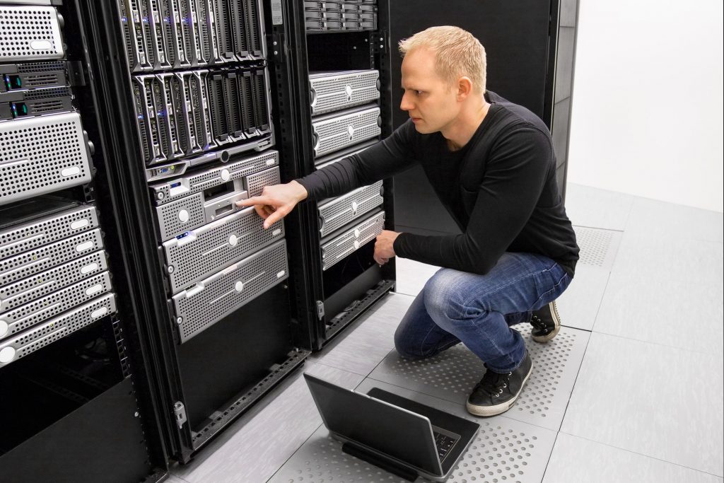 It consultant work with laptop in datacenter